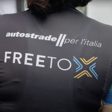 Text on the back of a cyclist's jersey: Autostrade per l'Italia - Free To X