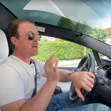 Uomo alla guida di un'auto elettrica