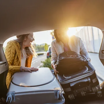 Due turiste caricano i bagagli in auto