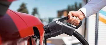 Dettaglio di una persona che ricarica l'auto elettrica